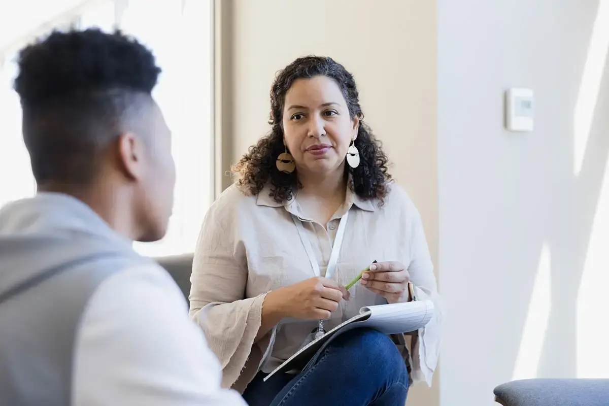 Counselor listens to the young adult and takes notes for their next meeting